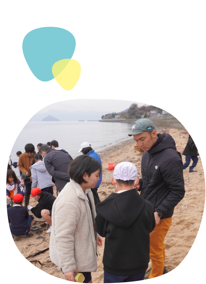 代表が小学生と回収した海洋ごみについて調べている様子